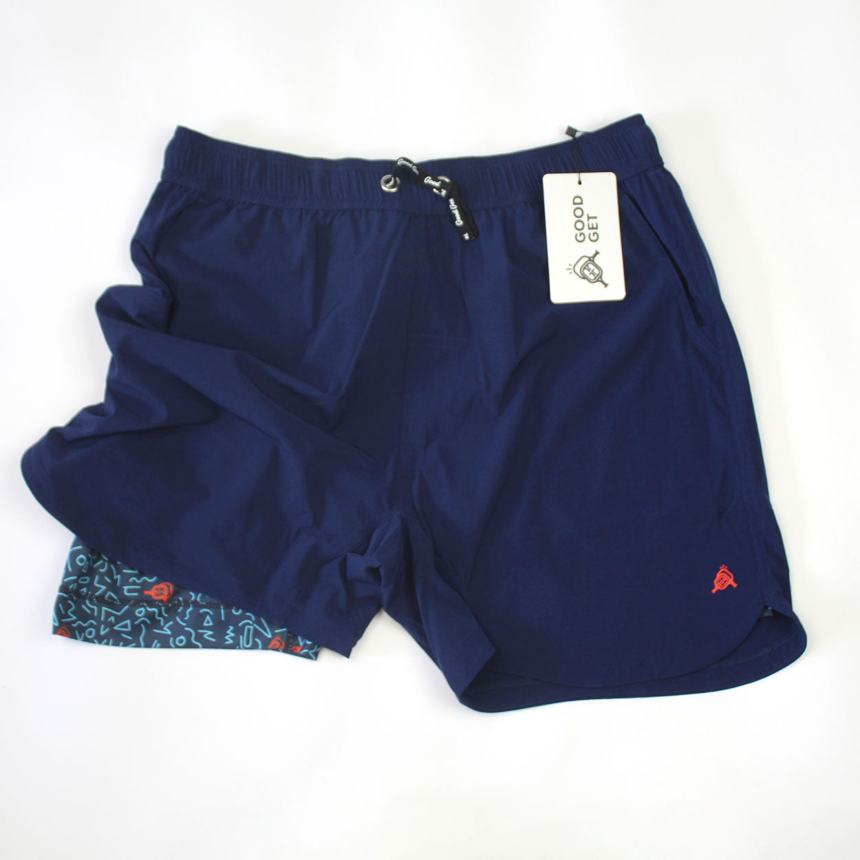 A pair of navy blue Good Get Pickleball Shorts, Court Clash Edition, featuring a black drawstring, colorful geometric inner lining, and a white GO GO GET tag with a rocket illustration.