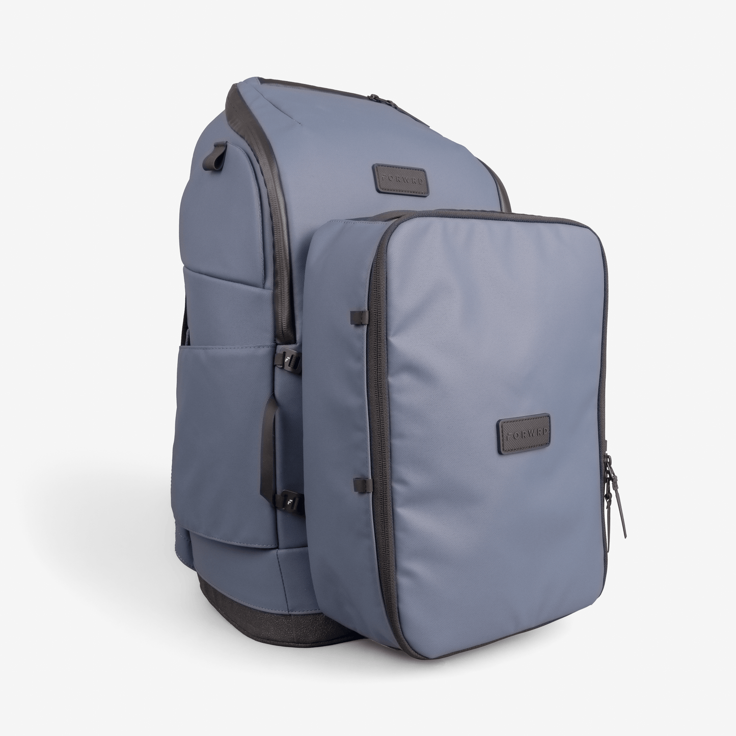 The FORWRD Court Caddy Shoe Cube is a light blue backpack with black zippers and accents, featuring a large detachable front compartment for packing, both with rectangular black FORWRD labels. The bag is displayed on a plain white background.