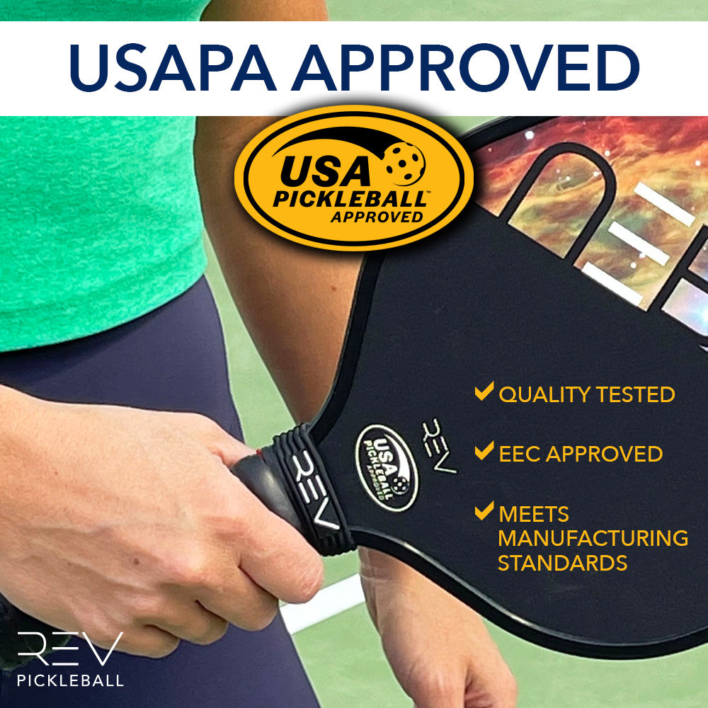 Close-up of a person holding a black NEBULA Pickleball Paddle by REV Pickleball with USA Pickleball Approved sticker. Text highlights USAPA approval, quality-tested honeycomb core, EEC compliance, and high manufacturing standards. Green shirt and blue shorts visible.