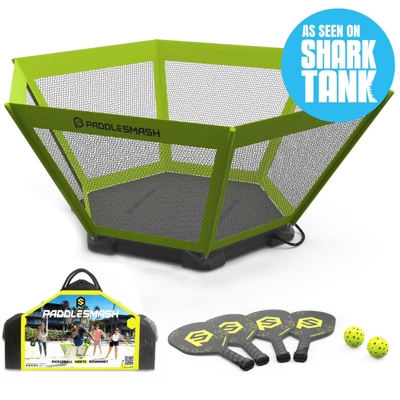 A green, hexagonal PaddleSmash net from PaddleSmash stands upright outdoors with a carry case, three black paddles, and two yellow Pickleball balls in front. A blue badge in the corner reads “As Seen on Shark Tank.”.