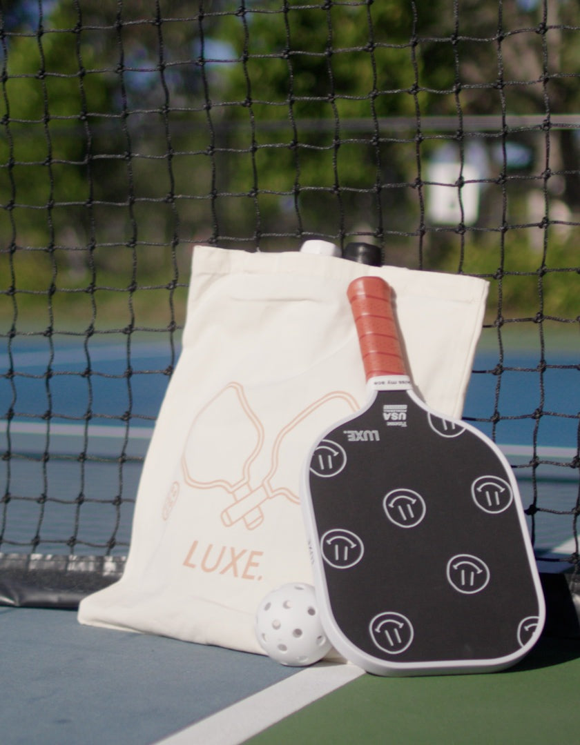The LUXE Pickleball Tote Bag is perfect for carrying your paddle, ball, net, and all your gear to the court in style.