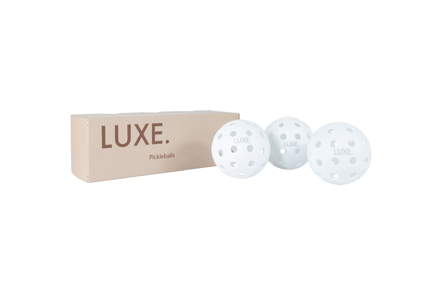 A beige LUXE Pickleball box sits beside three white, hole-punched LUXE Pickleballs—durable practice and tournament balls for indoor and outdoor play—displayed on a plain white background.
