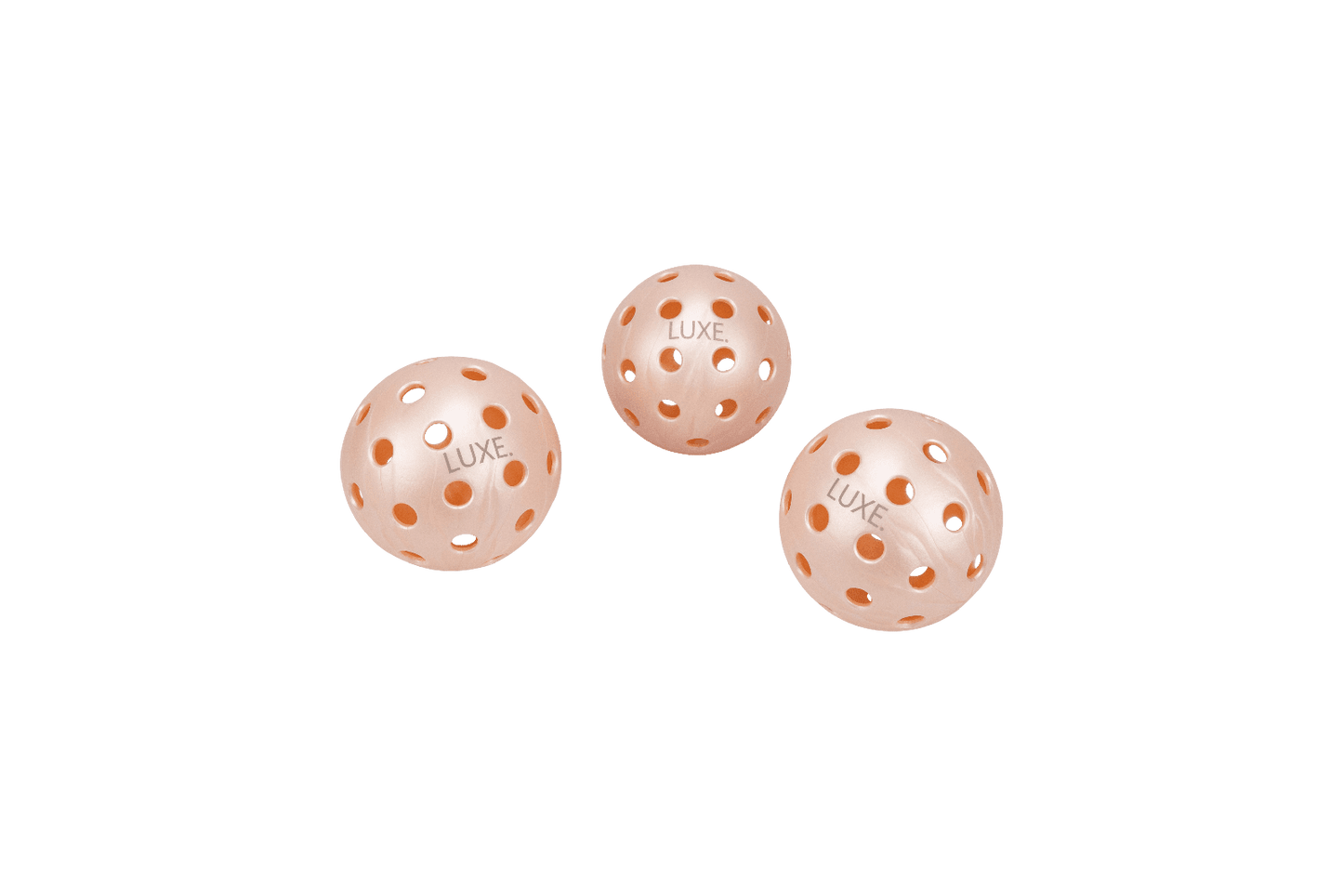 Three light pink pickleballs from LUXE Pickleball, each with "LUXE" printed on it, feature 40 evenly spaced circular holes. They are sold as the Pink Pickleballs - Pack of 3 and shown on a plain white background.