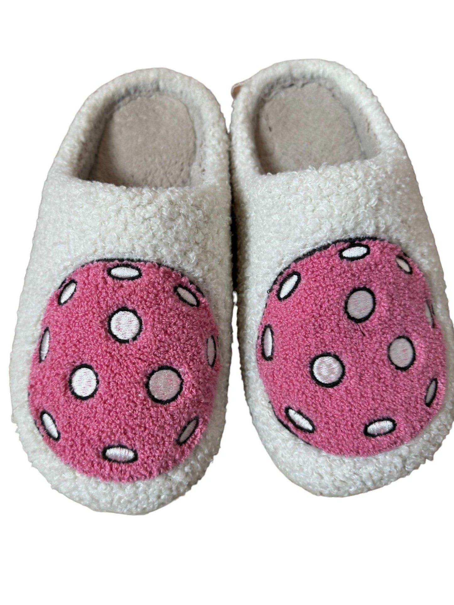 Fresh Pickle's Pickleball Slippers are fuzzy white closed-toe slippers with large pink polka-dot circles on top and soft gray inner soles, offering cozy comfort—perfect to pair with your favorite pickleball pjs.