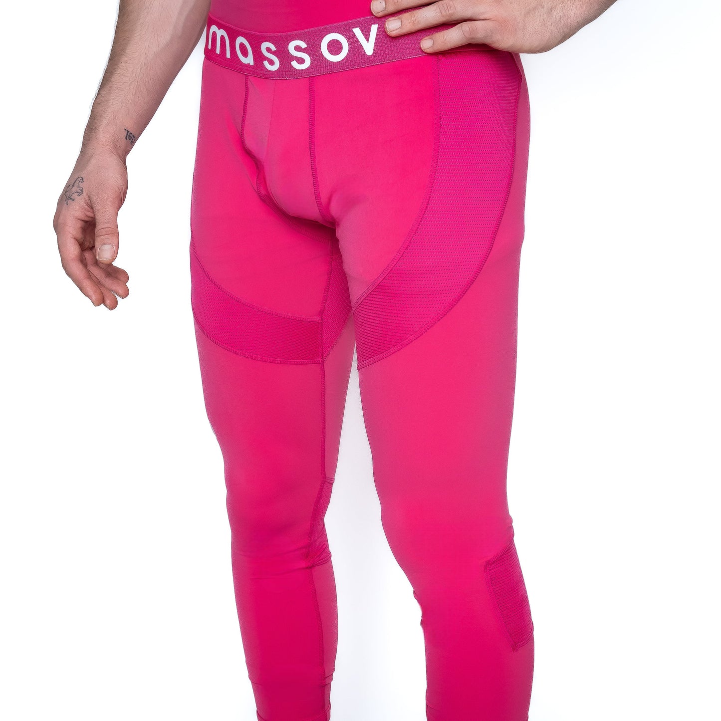 A boy stands against a white background wearing form-fitting ProForm® Boys' Compression Pants by Massov. Only his lower torso and legs are shown, with one hand on his hip, revealing a small tattoo.