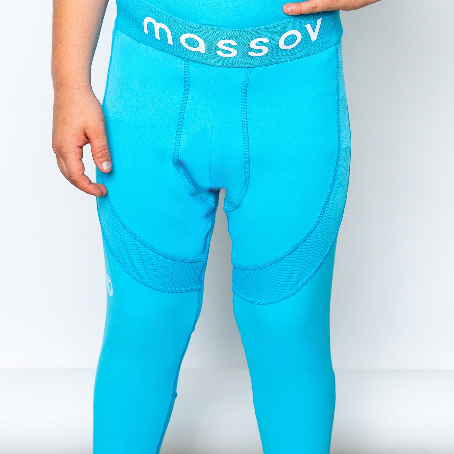 The ProForm® Boys' Compression Pants by Massov are bright blue athletic tights with the brand name in white on the waistband, modeled against a plain white background with the child's hands by their sides.