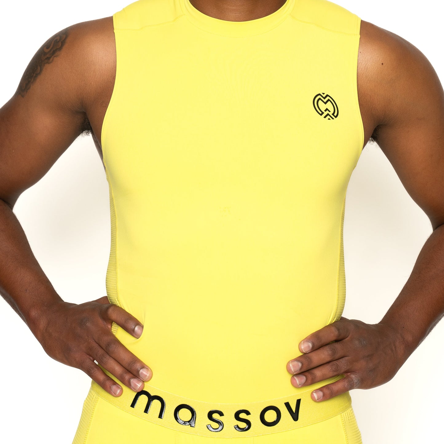 A youth boy wears the ProForm® Boys' Compression Tank Top by Massov—a bright yellow, sleeveless athletic shirt with a small black heart logo on the chest and "massov" in black on the waistband. Only his torso and arms are visible.