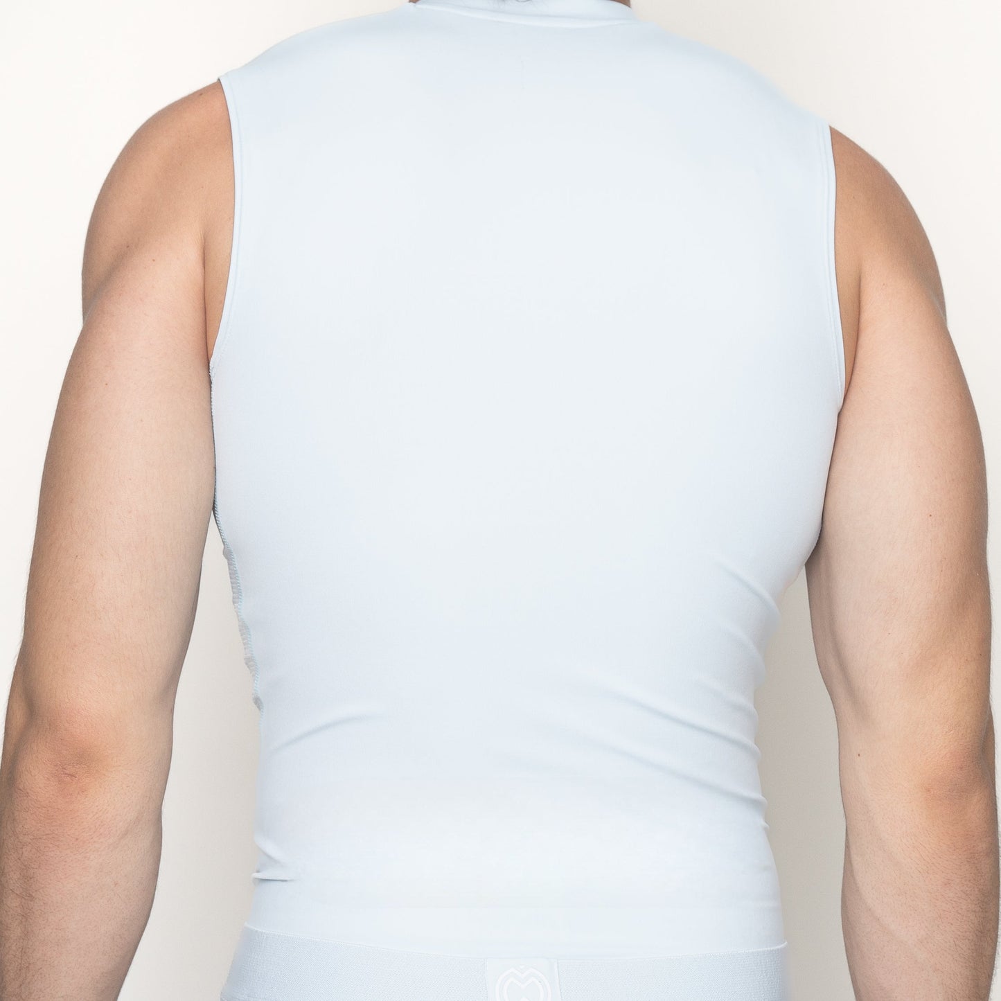 A muscular person is shown from the back, wearing a sleeveless light blue Massov ProForm® Boys' Compression Tank Top. Their arms are bare, with a plain, light background.