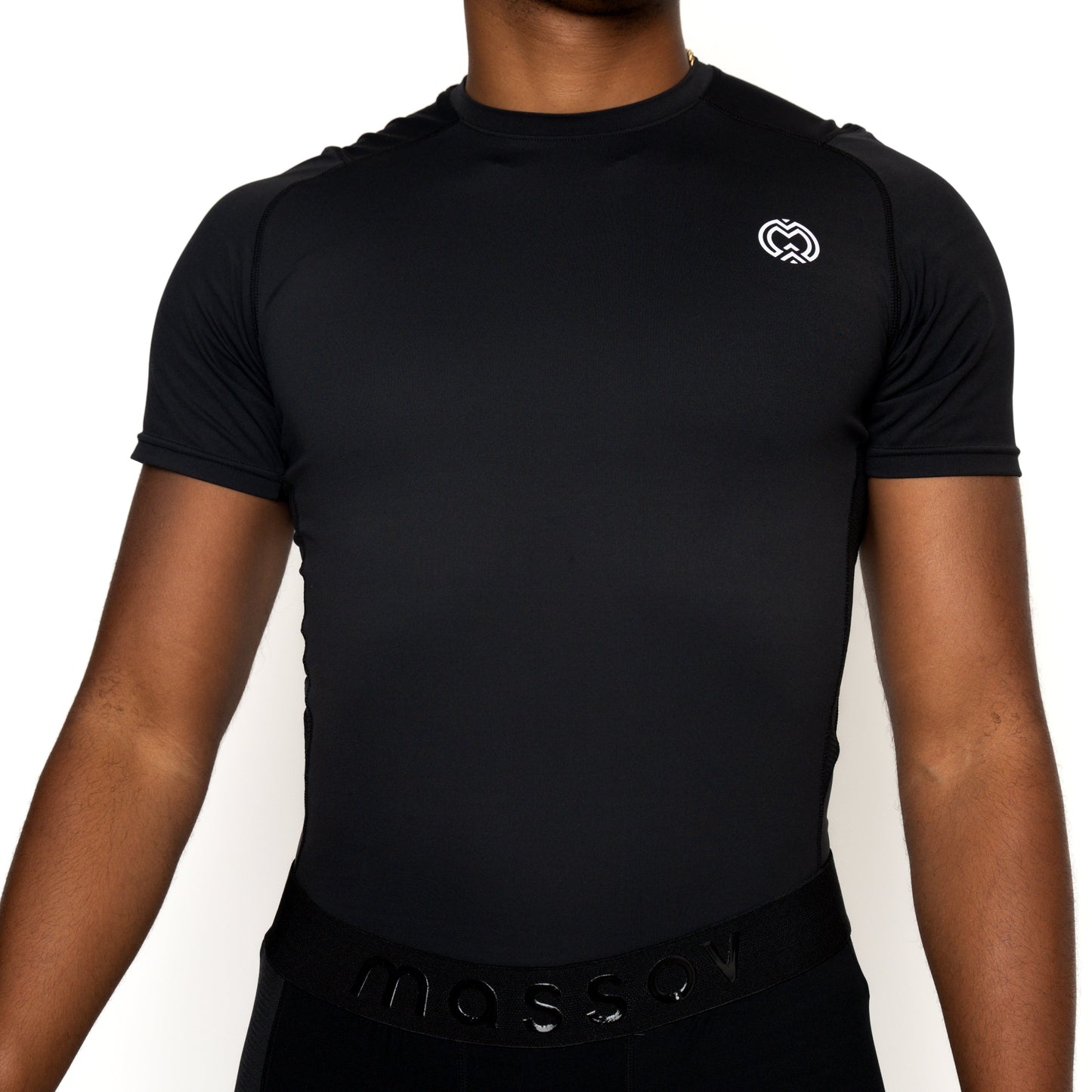 A person models the ProForm® Boys' Short Sleeve Compression Shirt by Massov, a fitted black athletic top with UPF protection, a small white logo on the left chest, "massov" on the waistband, against a plain white background; head not visible.