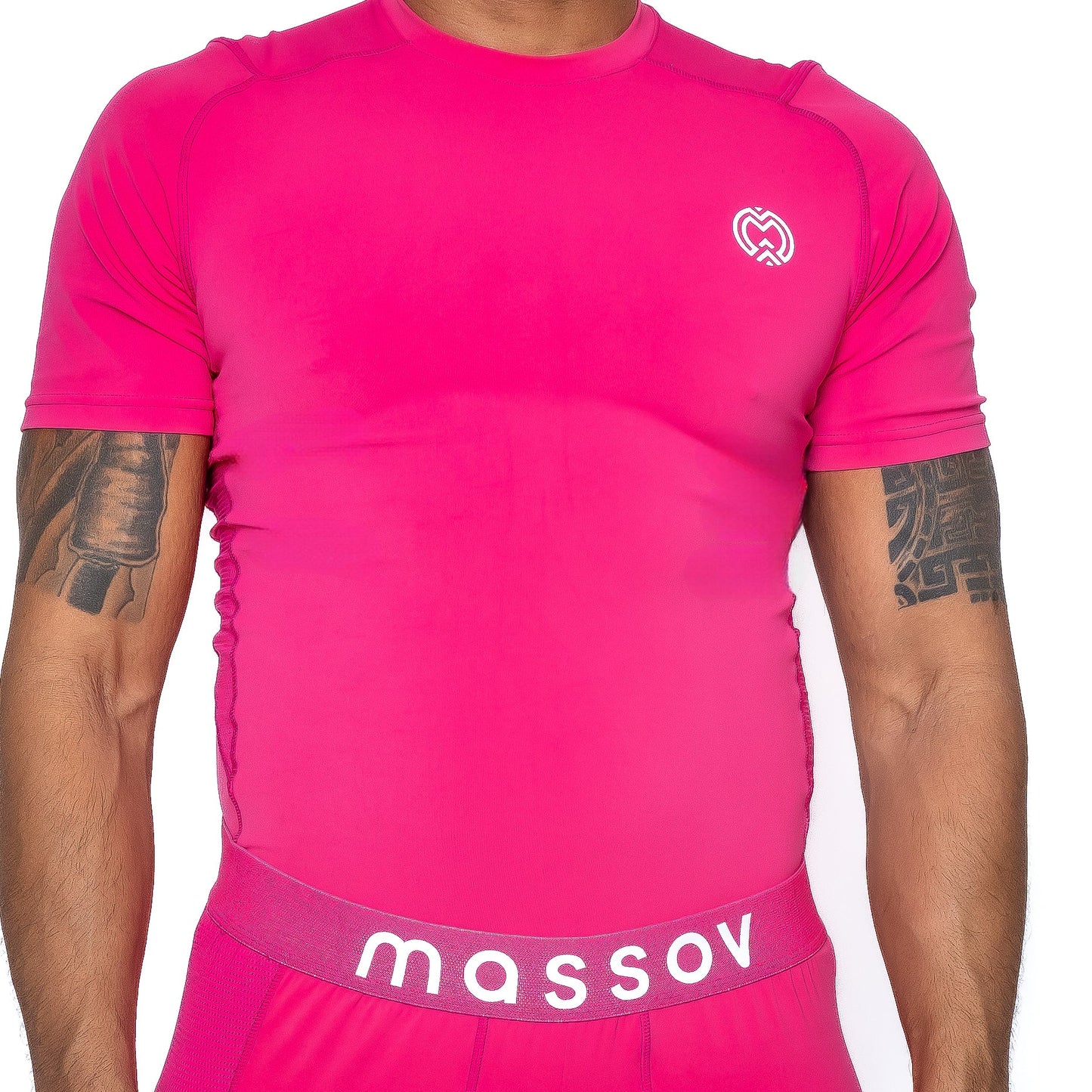 A person wears the Massov ProForm® Men’s Short Sleeve Compression Shirt in bright pink, featuring a white heart logo on the chest and a matching pink “massov” waistband. Their tattooed arms are partly visible against a plain white background.