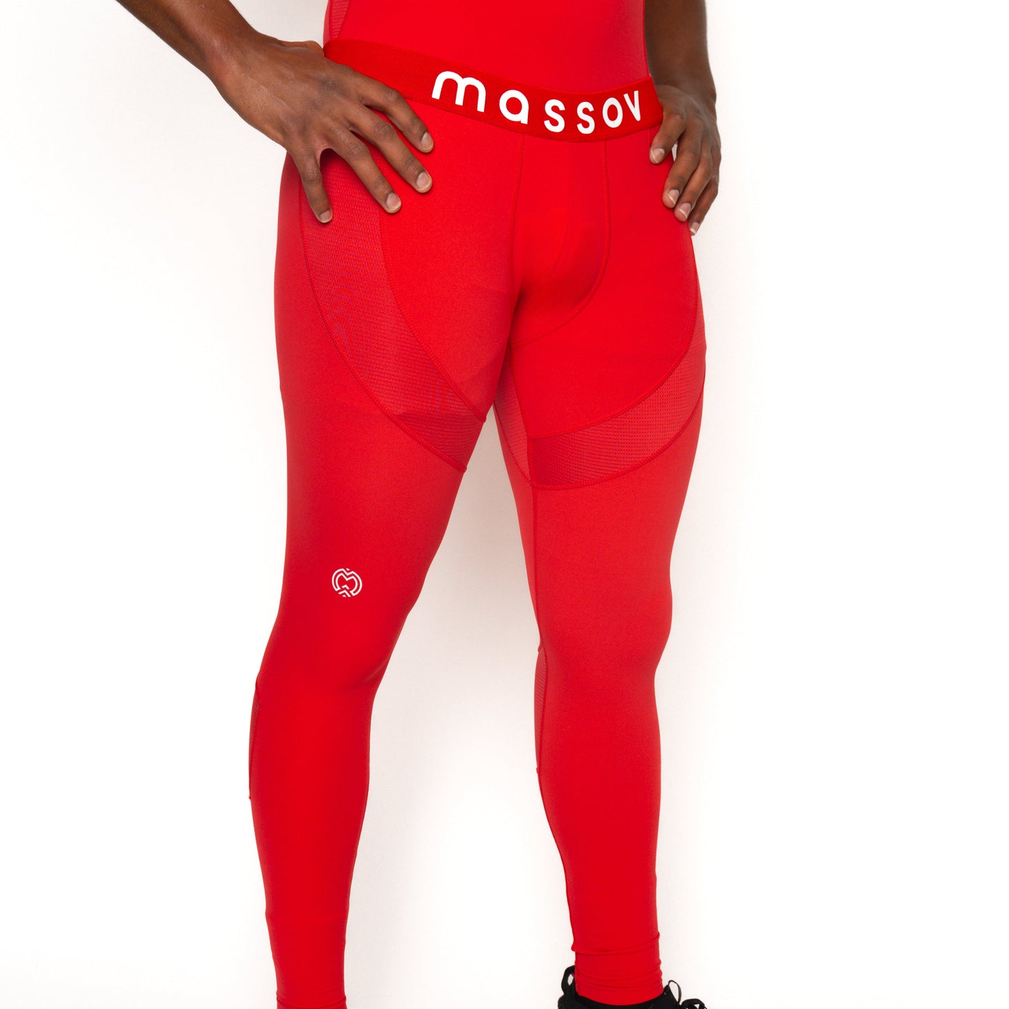 A man poses against a white background in Massov ProForm® Men's Compression Pants, featuring a bold logo waistband and small white thigh logo. His hands on his hips highlight moisture-wicking comfort from mid-torso to feet.