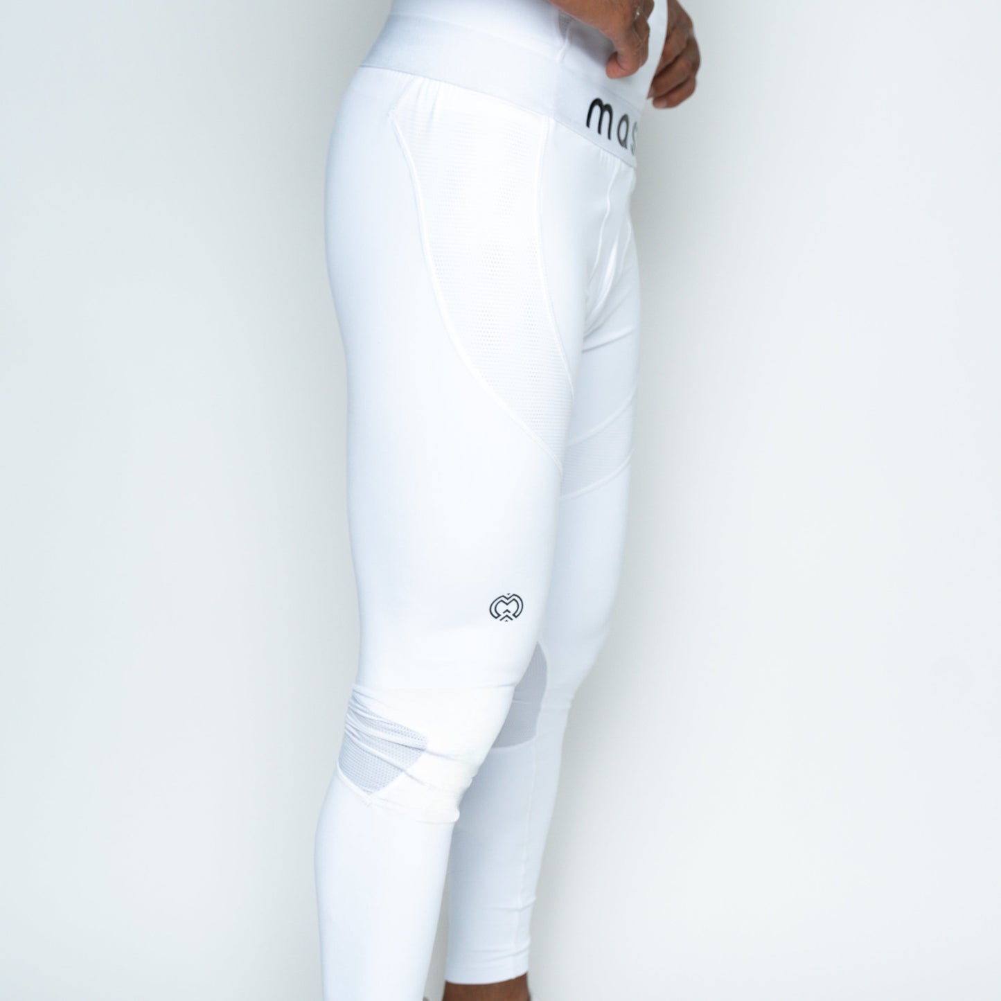 A person models Massov ProForm® Men's Compression Pants in white against a plain background, showing only the lower torso and legs. The high-waisted leggings have a small logo near the knee and a branded waistband with partial lettering.