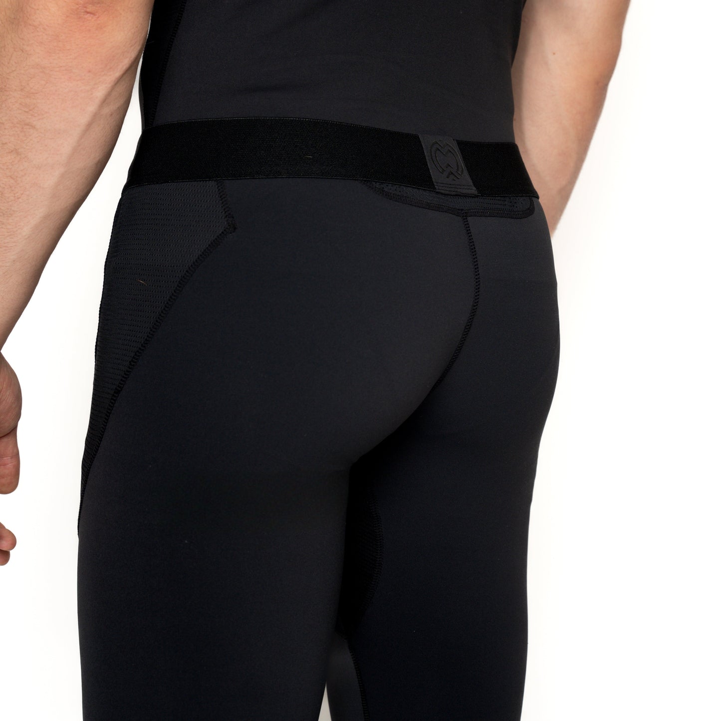 A person is shown from the waist down wearing Massov ProForm® Men's Compression Pants, highlighting the seamless, snug fit and moisture-wicking design on the back and side.