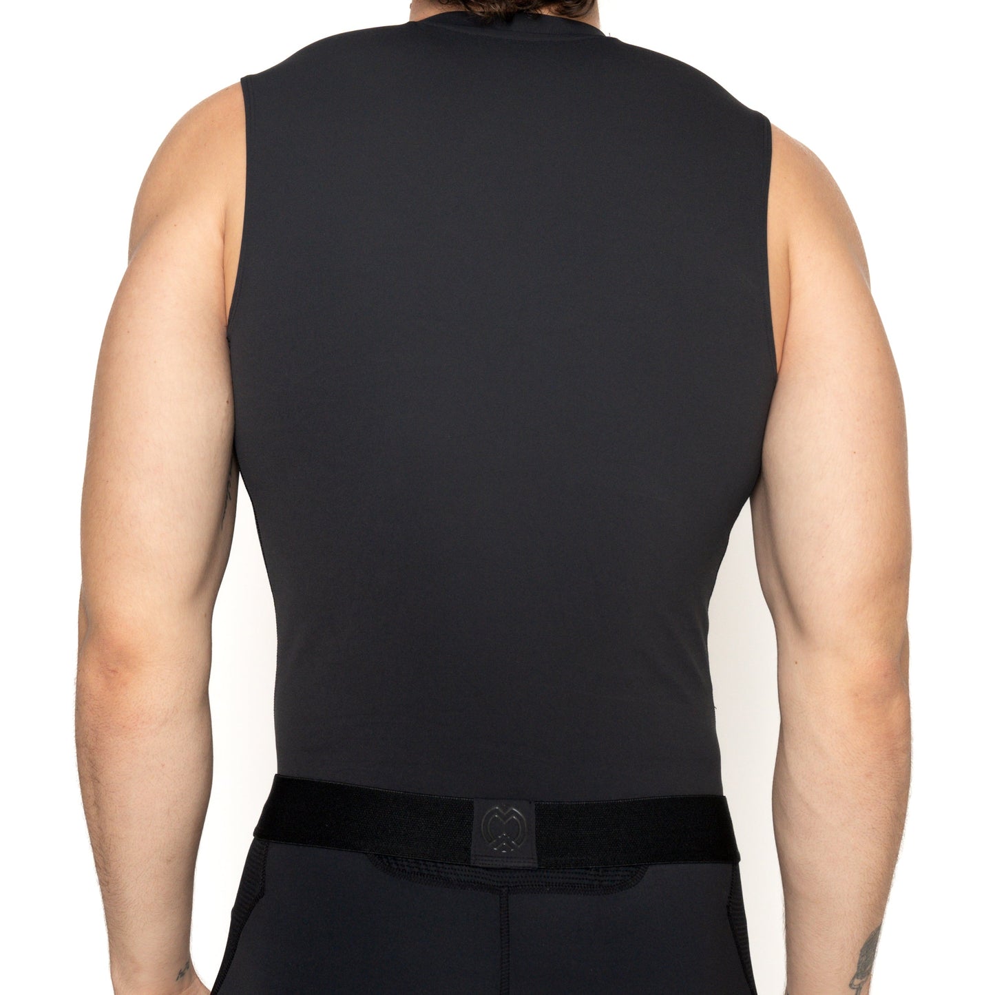 A light-skinned, short-haired person is seen from the back against a plain white background, wearing a Massov ProForm® Men's Compression Tank Top and a wide black waist belt, with arms relaxed at their sides.