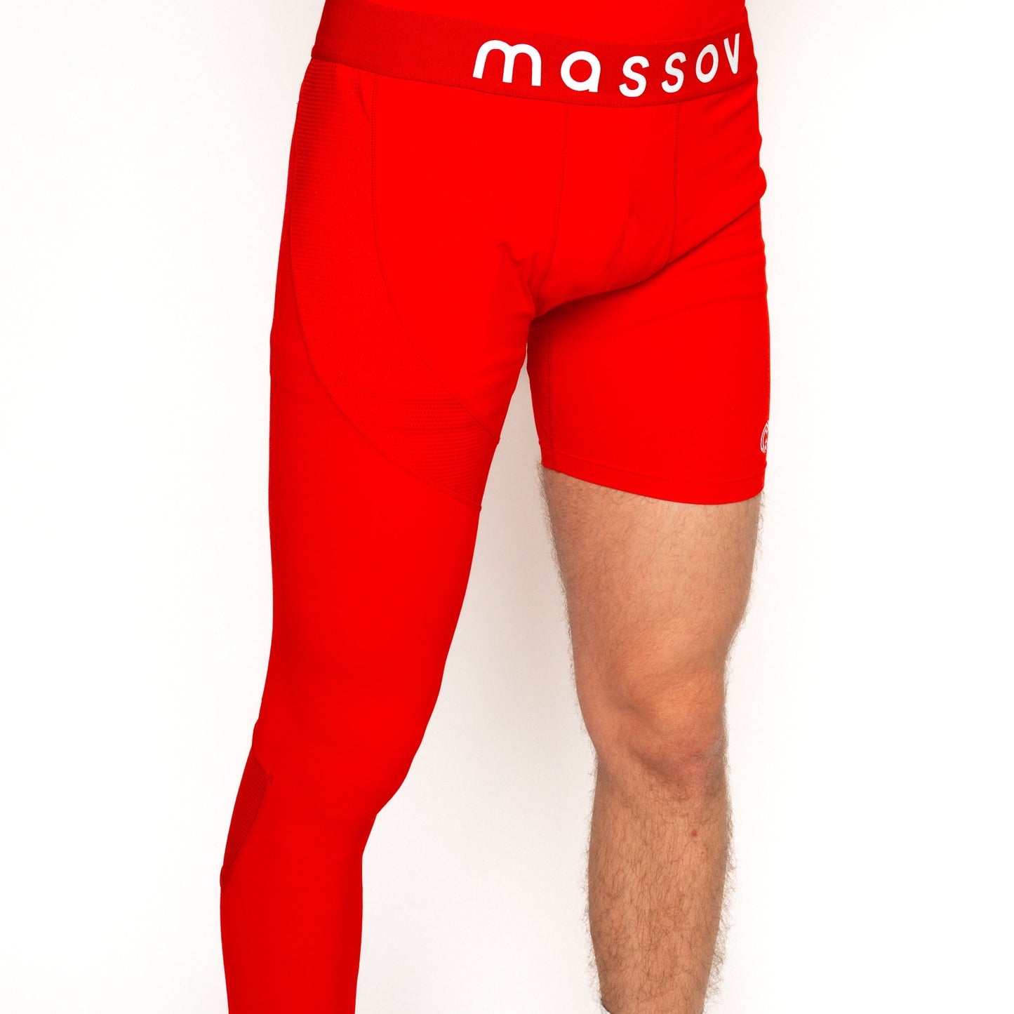 A boy models the Massov ProForm® Youth Boys' One Leg Compression Pants—bright red with shorts on one leg and compression tights on the other, “massov” in white on the waistband. Only his lower torso and legs appear against a plain white background.