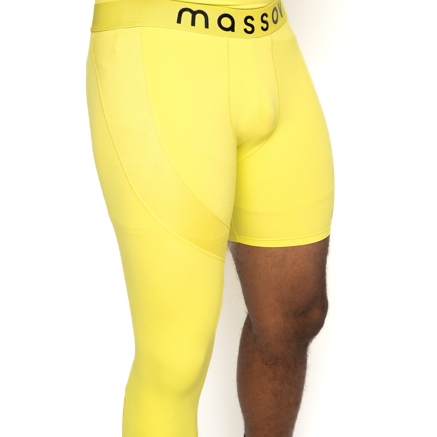 A person wears ProForm® Youth Boys' One Leg Compression Pants by Massov in bright yellow; the mass-branded waistband is visible. The image, on a white background, is cropped mid-torso to knees, showing one bare and one covered thigh.