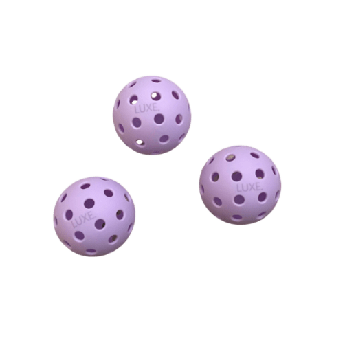 Three LUXE Pickleball Purple Pickleballs—each with 40 evenly spaced holes and the LUXE logo—are arranged on a plain, light background. Pack includes 3 outdoor balls.