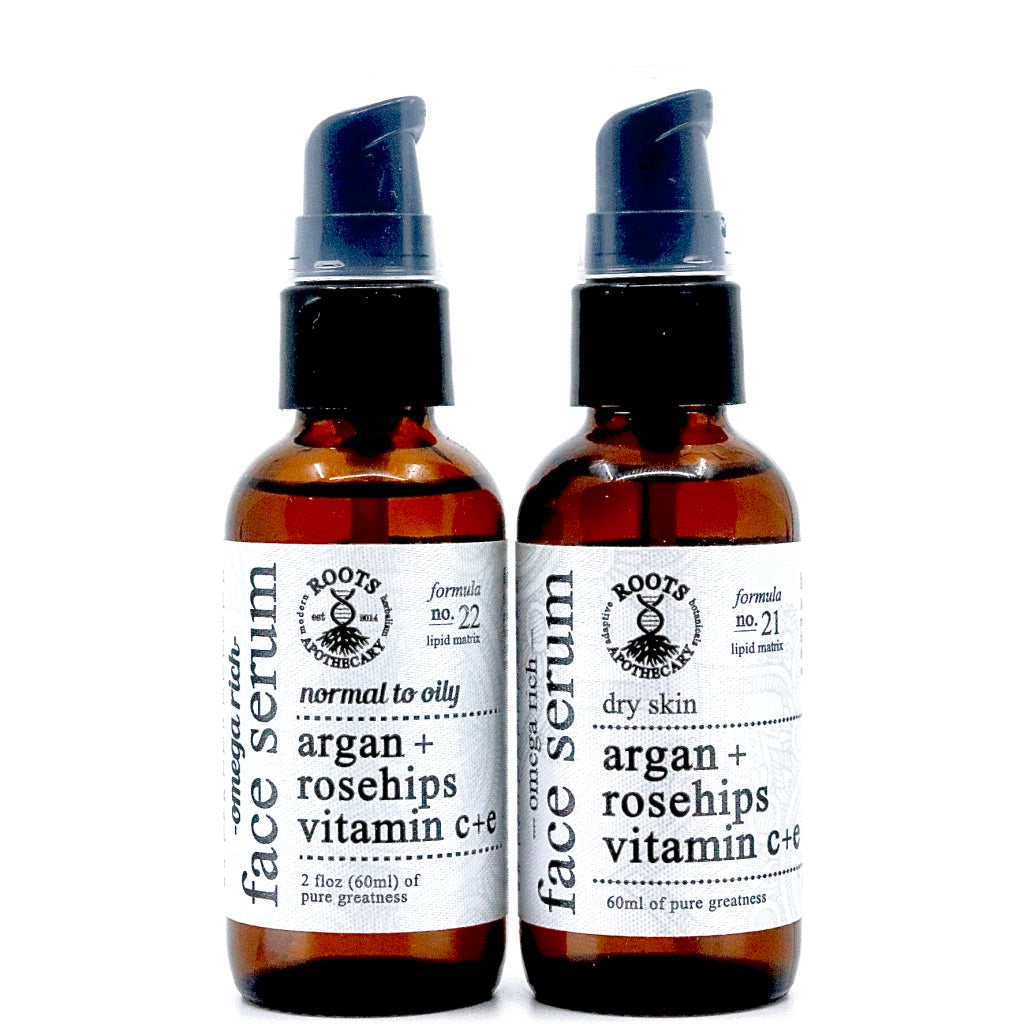 Two 60ml amber pump bottles of Roots Apothecary face serum: Formula 22 for normal to oily skin and Formula 21 for dry skin. Each antioxidant serum blends unrefined argan oil, rosehips, and vitamins C & E.