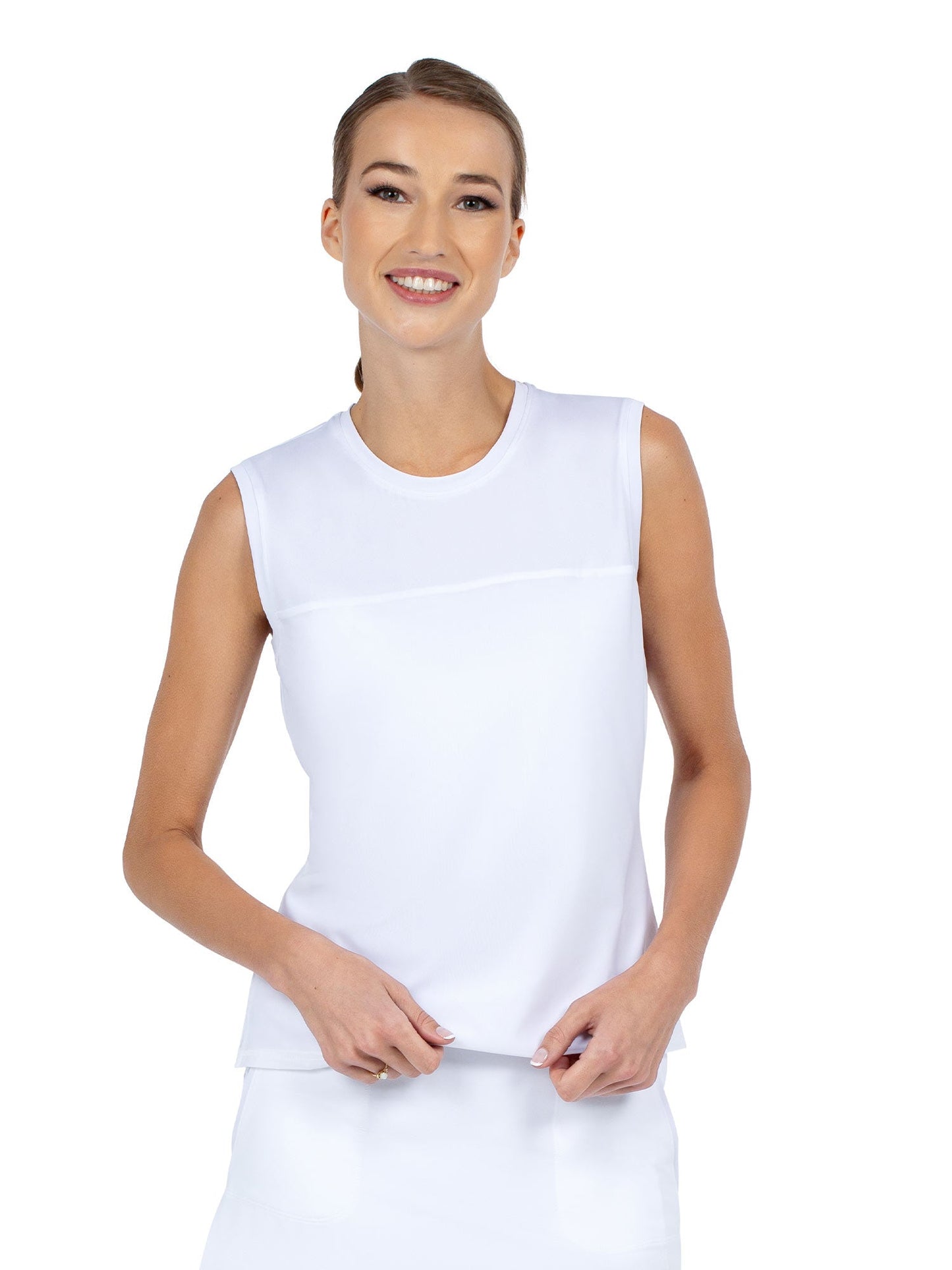 A smiling woman with light skin and blond pulled-back hair wears the inPhorm NYC Relax-Fit Crewneck Tank with Light Mesh Overlay in white, facing forward and gently holding the hem. The background is plain white.