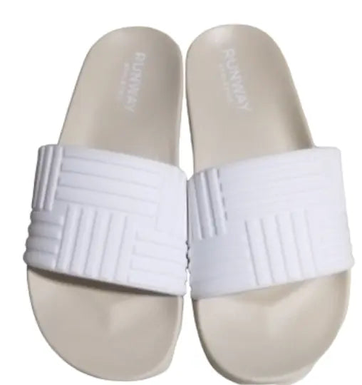 The Runway Athletics Resort Slides feature white geometric-patterned embossed upper straps and smooth footbeds. These minimalist, open-toe slides are arranged side by side and viewed from above on a white background.
