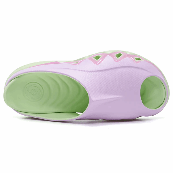 The BPBazaar Rigorer Shark 3 Slides 'Pink/Green' feature a wavy green sole and light purple upper with cutouts and open heel, blending sports sandal comfort with bold, modern style. Shown from the bottom and side for detail.