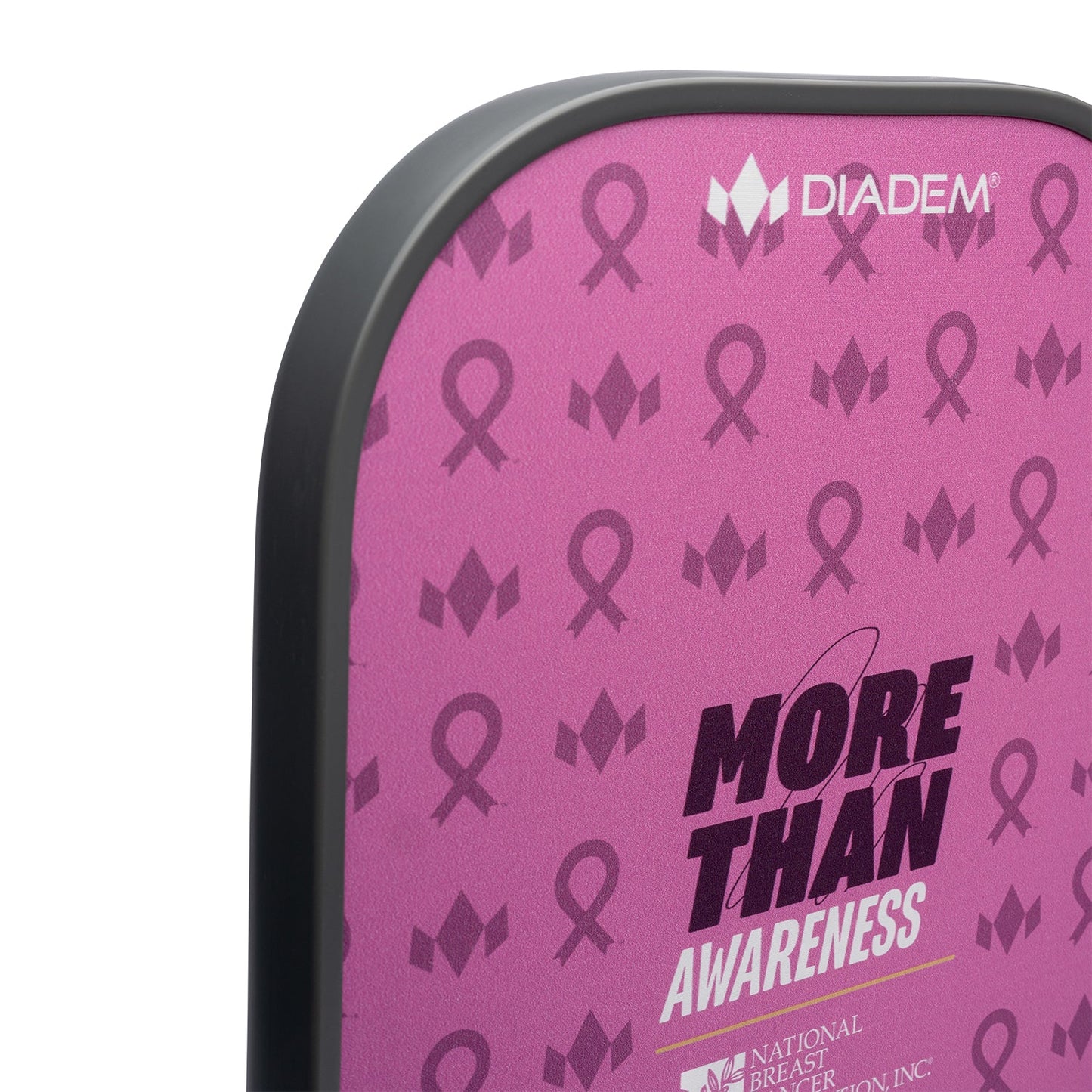 A close-up of the pink Diadem Sports Rush Pickleball Paddle with a black edge, decorated with dark pink breast cancer ribbons, “MORE THAN AWARENESS,” the Diadem logo, and the National Breast Cancer Foundation logo. USAPA approved.