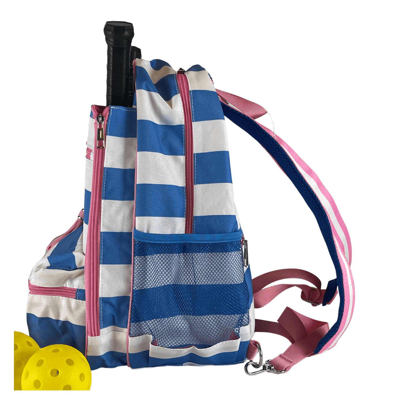The Fresh Pickle Teddi Pickleball Backpack features blue and white stripes, pink straps and zippers, a front pocket for a black-handled racket, a mesh side pocket, and two yellow perforated pickleballs visible in the bottom left corner.