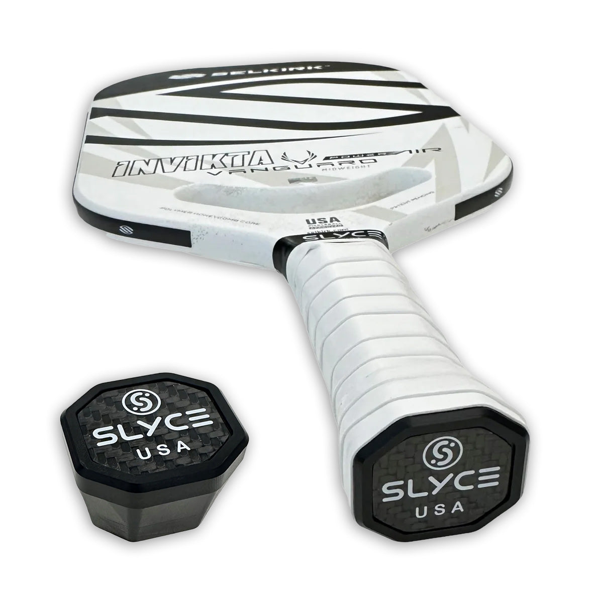 A white Selkirk pickleball paddle with black accents and "INVICTA" text rests at an angle. In front are two Slyce Sport SLYCE Weighted SpeedCap (15g, 1/2oz.) Paddle Performance Enhancers, perfect for customizing your grip cap.