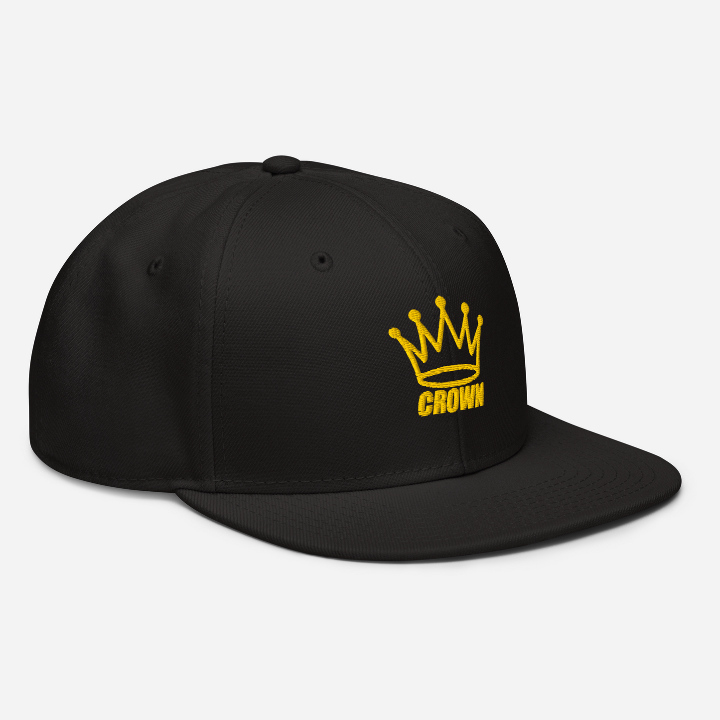 The Crown Pickleball Corona Snap-back Hat in black features a yellow embroidered crown and "CROWN" on the front, an adjustable fit with ventilation eyelets, and is shown angled right on a plain white background.