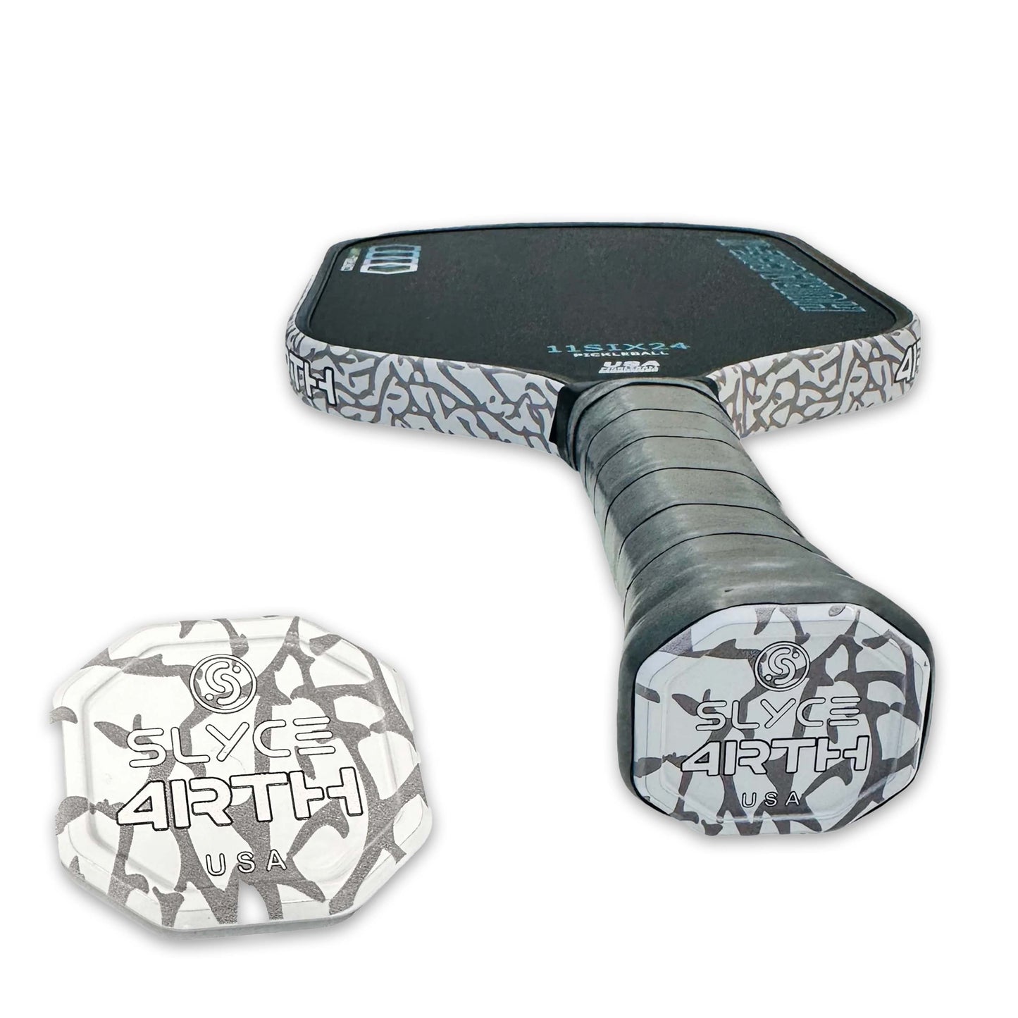 A close-up of Slyce Sport’s Special Edition 4rth Elephant Print SpeedCap (28g, 1.0 oz.) Paddle Performance Enhancer shows its black face, gray patterned edges, and bold SLYCE ARTH USA over a gray abstract background.