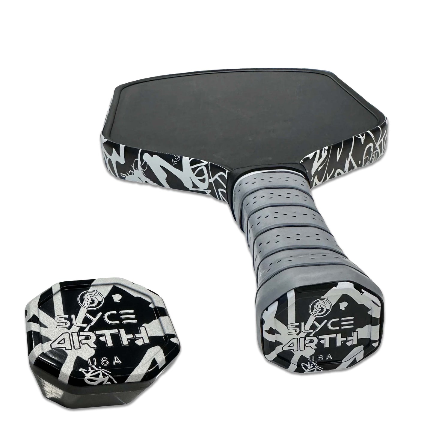 A Special Edition 4rth Graffiti White SpeedCap (28g, 1.0 oz.) Paddle Performance Enhancer by Slyce Sport sits beside a black and gray pickleball paddle with abstract patterns and SLYCE ARTH USA text, sharing the same stylish design.