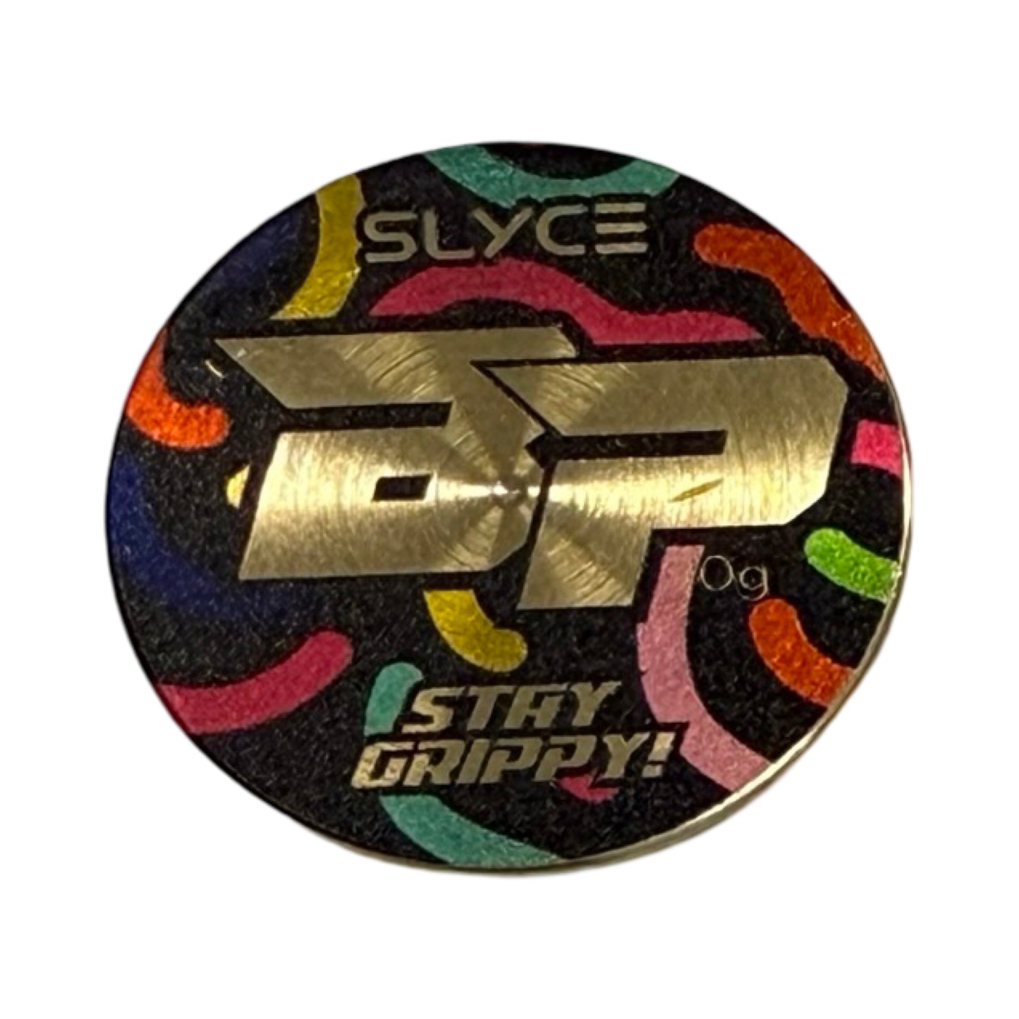 A round, black token from Slyce Sport’s Special Edition Bodhi Chocolate Birthday Cake SpeedCoins features a metallic gold BP, SLYCE above, 0g to the right, “STAY GRIPPY!” at the bottom, and colorful lines like premium paddle handle weights.