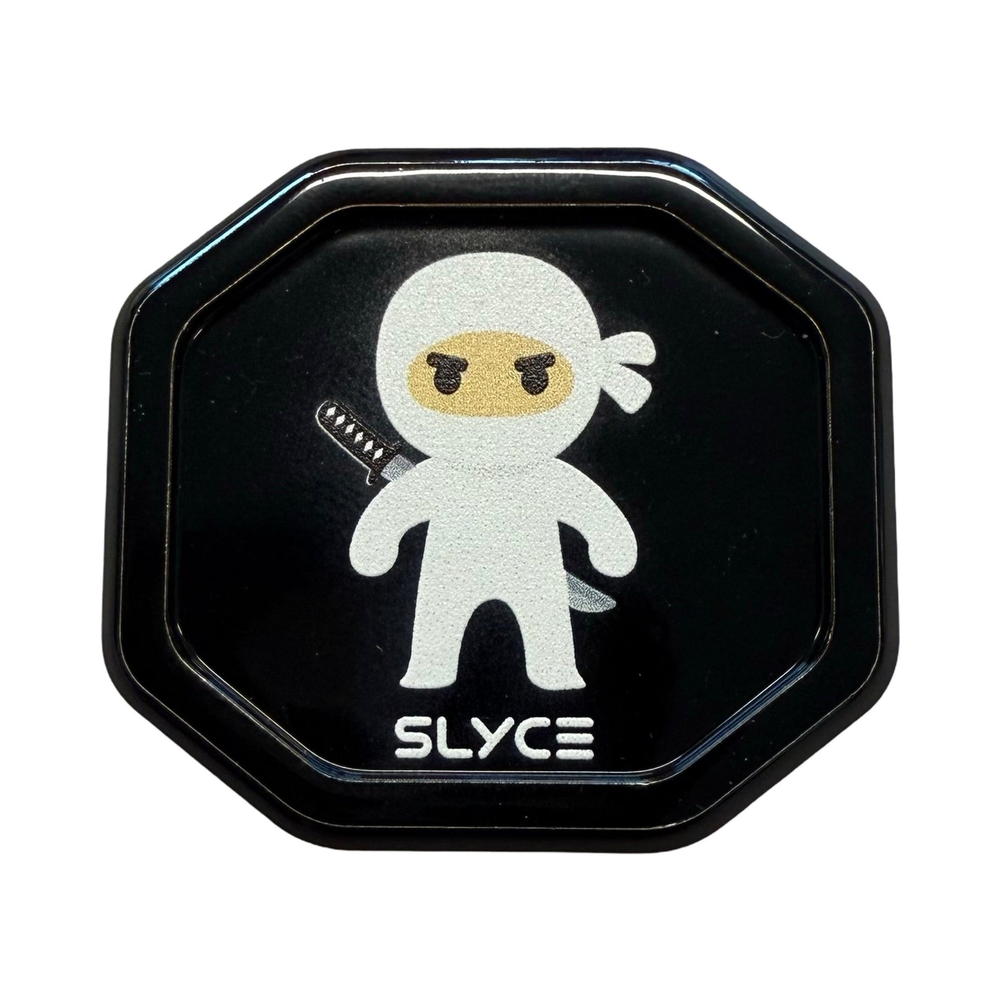 A black octagonal badge for Special Edition Dink Ninjas SpeedCaps by Slyce Sport shows a white-clad cartoon ninja with yellow eyes and a sword, above bold futuristic "SLYCE" text—all on a solid black background, inspired by paddle precision.