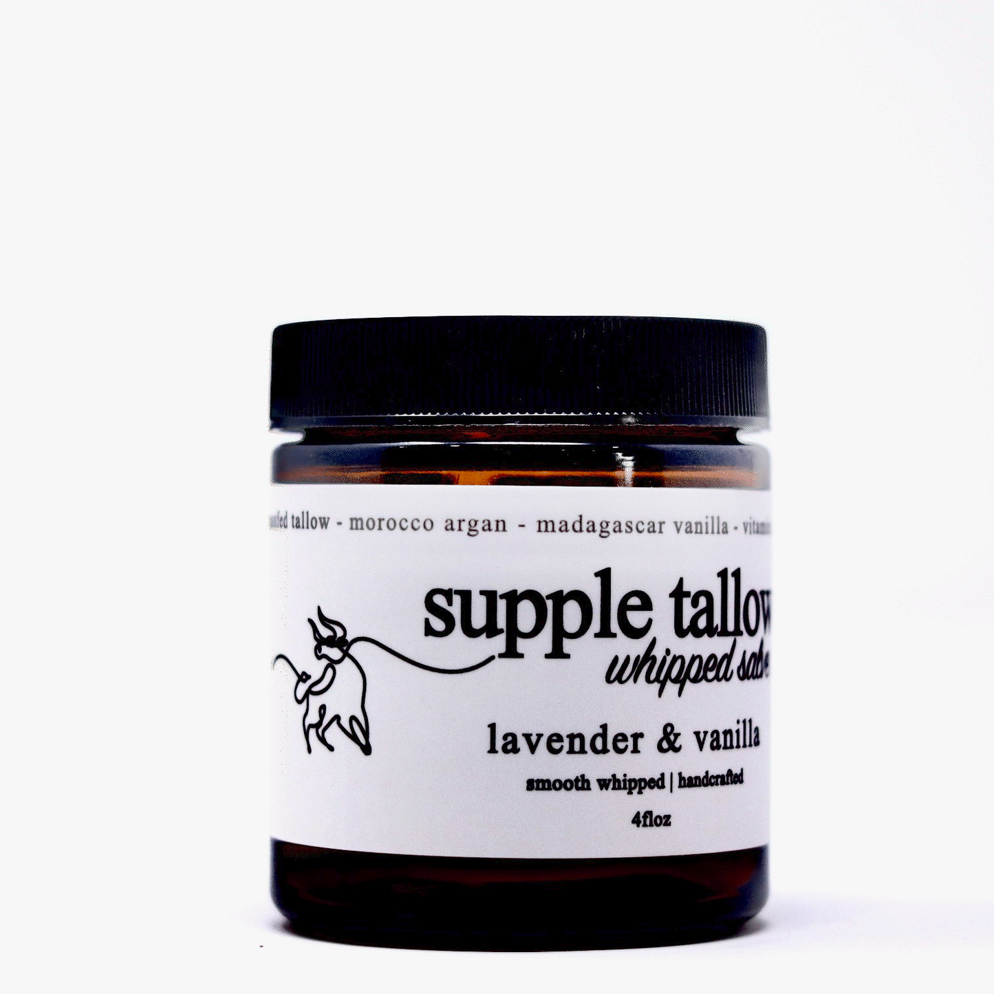 A brown glass jar with a black lid labeled "supple tallow salve" by Roots Apothecary. Label notes grassfed tallow, lavender & vanilla scent, smooth whipped texture, handcrafted organic skincare, 4 fl oz, and a cow line drawing. White background.