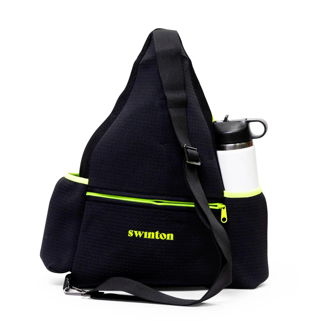 The Swinton Pickleball Sling Bag in black features neon yellow zippers, "swinton" embroidered on the front pocket, adjustable strap, side pockets (one with a white water bottle), and is shown on a plain white background. Personalization available.