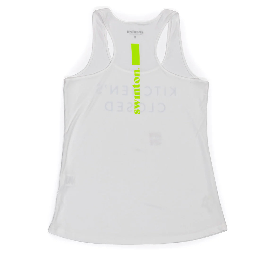 A white Swinton Pickleball Performance Tank is laid flat, featuring faint blue “KITCHEN’S CLOSED” text in reverse and a vertical neon green “symphon” stripe. The Swinton Pickleball brand name appears faintly inside the collar.