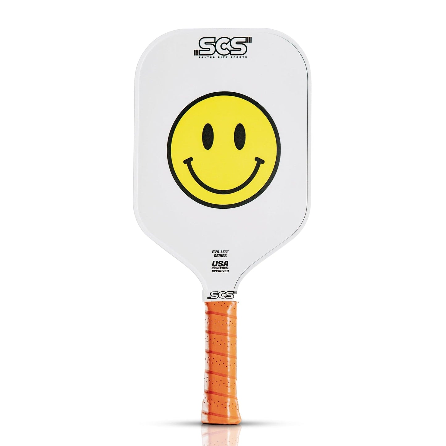 The Happy Paddle | Evo-Lite Series by Salted City Sports is a white pickleball paddle with an orange grip, a large yellow smiley face in the center, “SCS” logo at top, and “USA Pickleball approved” text below the smiley.