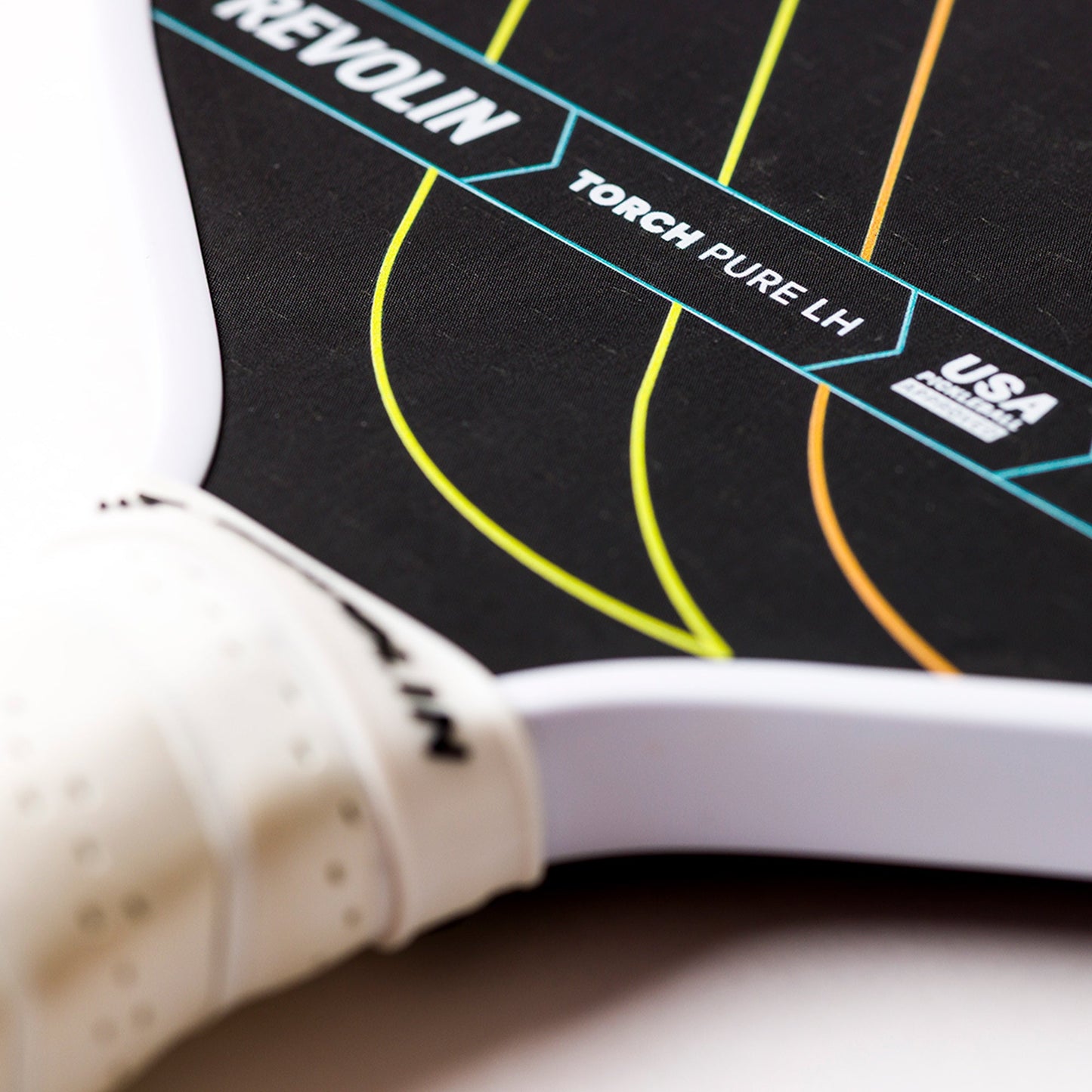 Close-up of the lightweight Revolin Sports Torch Pure LH Pickleball Paddle with white edges and grip, featuring curved yellow and green lines. Text includes TORCH PURE LH, REVO LIN, USA PICKLEBALL APPROVED to highlight branding details.