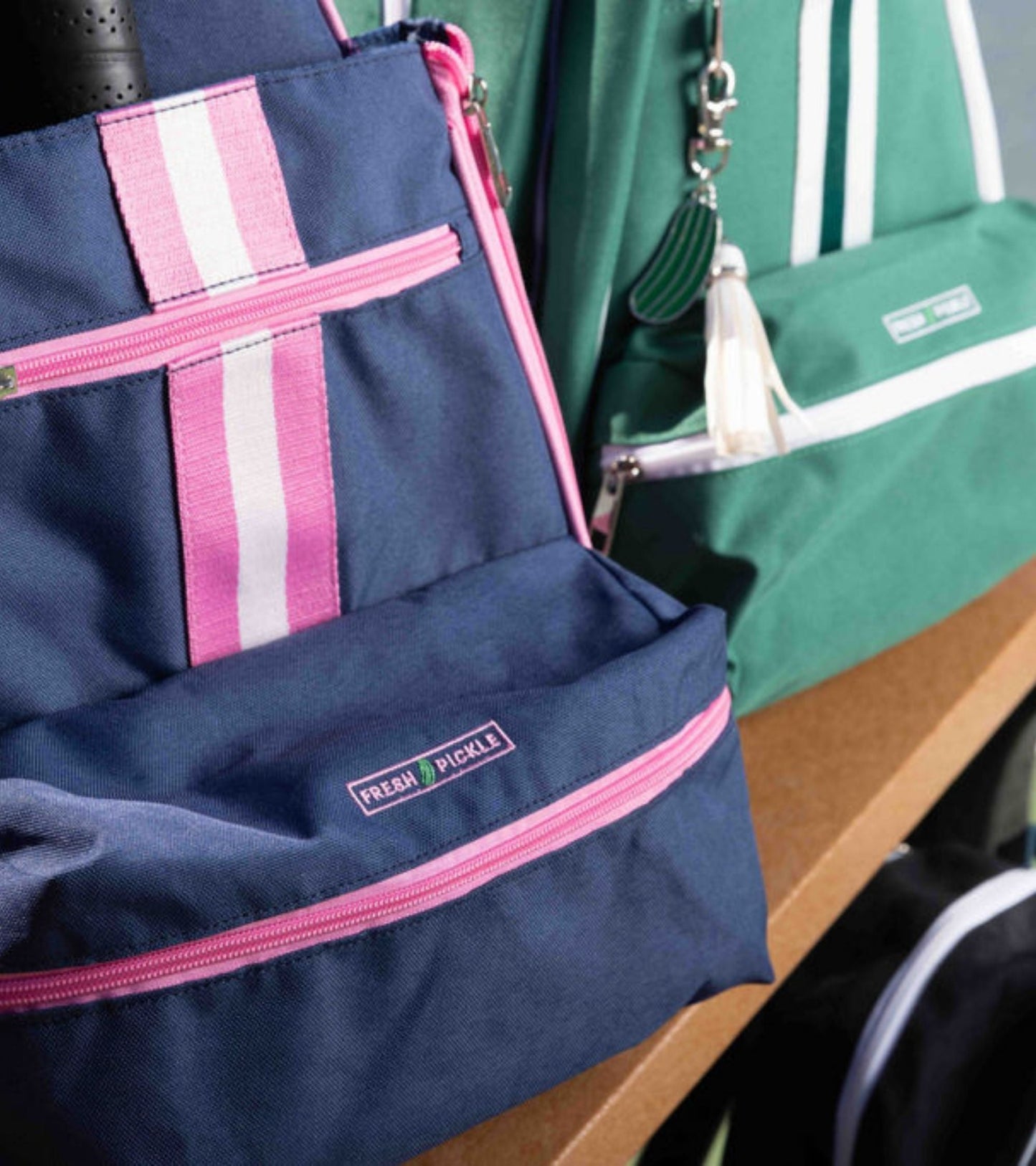 Close-up of two Fresh Pickle Teddi Pickleball Backpacks on a wooden bench: both boast a modern, athletic style and roomy interiors for hands-free convenience on the go.