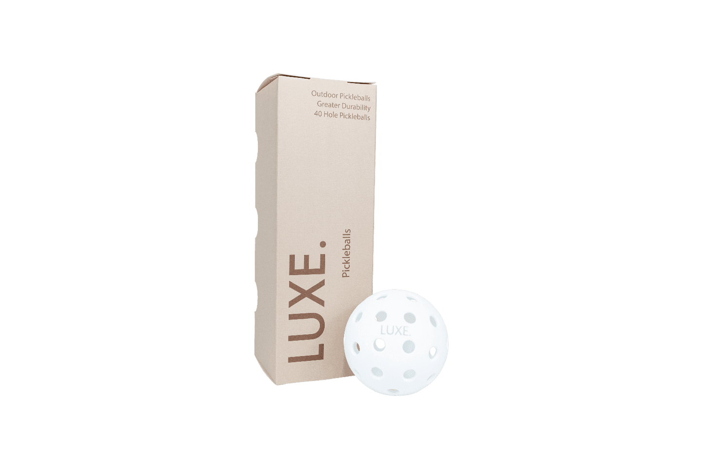 A beige LUXE Pickleball box stands upright beside a white pickleball with LUXE branding. The box features "White Pickleballs - Pack of 3," highlighting outdoor use, greater durability, and 40-hole design on a clean white background.