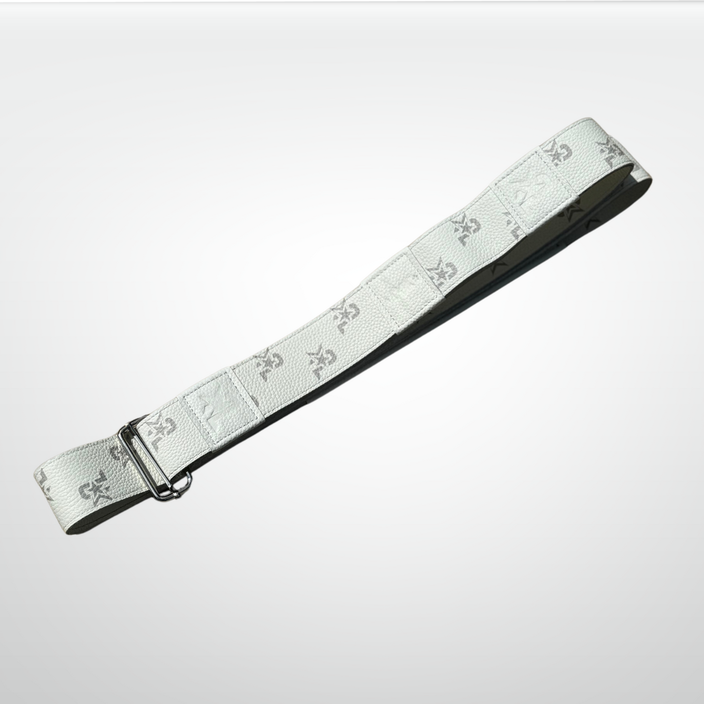 The iReliev I AM Leather Monogram Yoga Strap features a gray fleur-de-lis pattern on white leather with a metal buckle—an ideal luxury fitness accessory to elevate your collection.