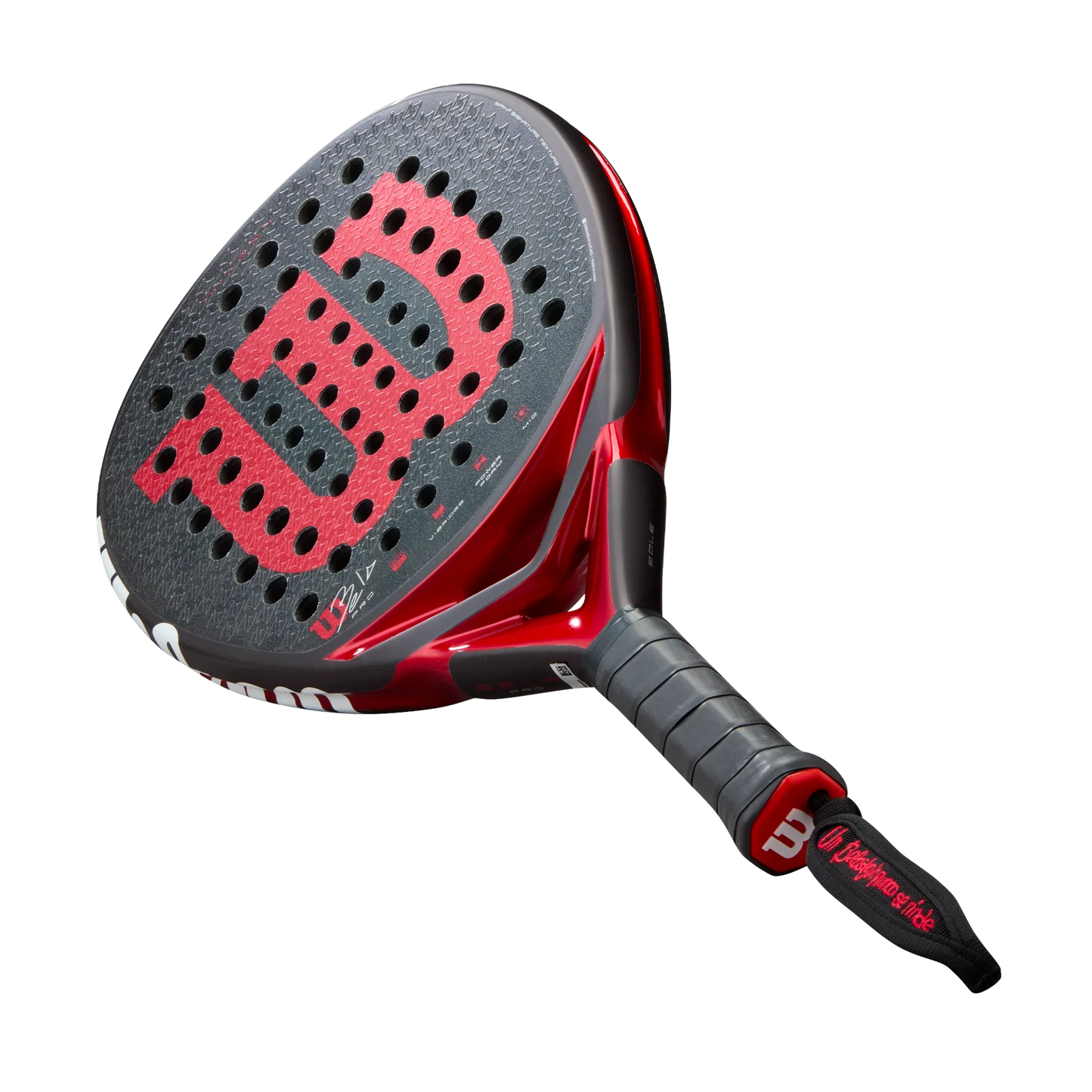 A close-up of the Padel USA Wilson Bela Pro V3 padel racket, featuring a 24K carbon face with round holes, a large red W logo, black grip, and a black wrist strap with red detail and "Courage on the Court" written on it.