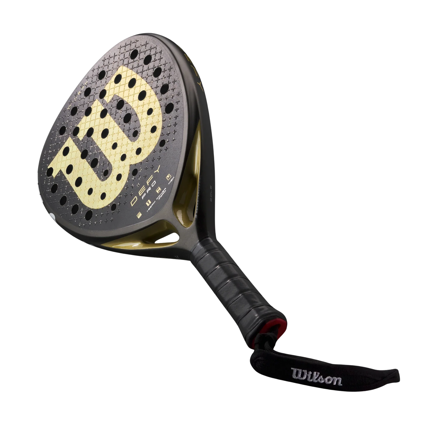 The Wilson Defy Pro V1 Padel Racket by Padel USA features a black and gold design with a 15K Carbon Face, round holes, wide surface, large gold "W" logo, black grip tape, and a Wilson-branded wrist strap for control.