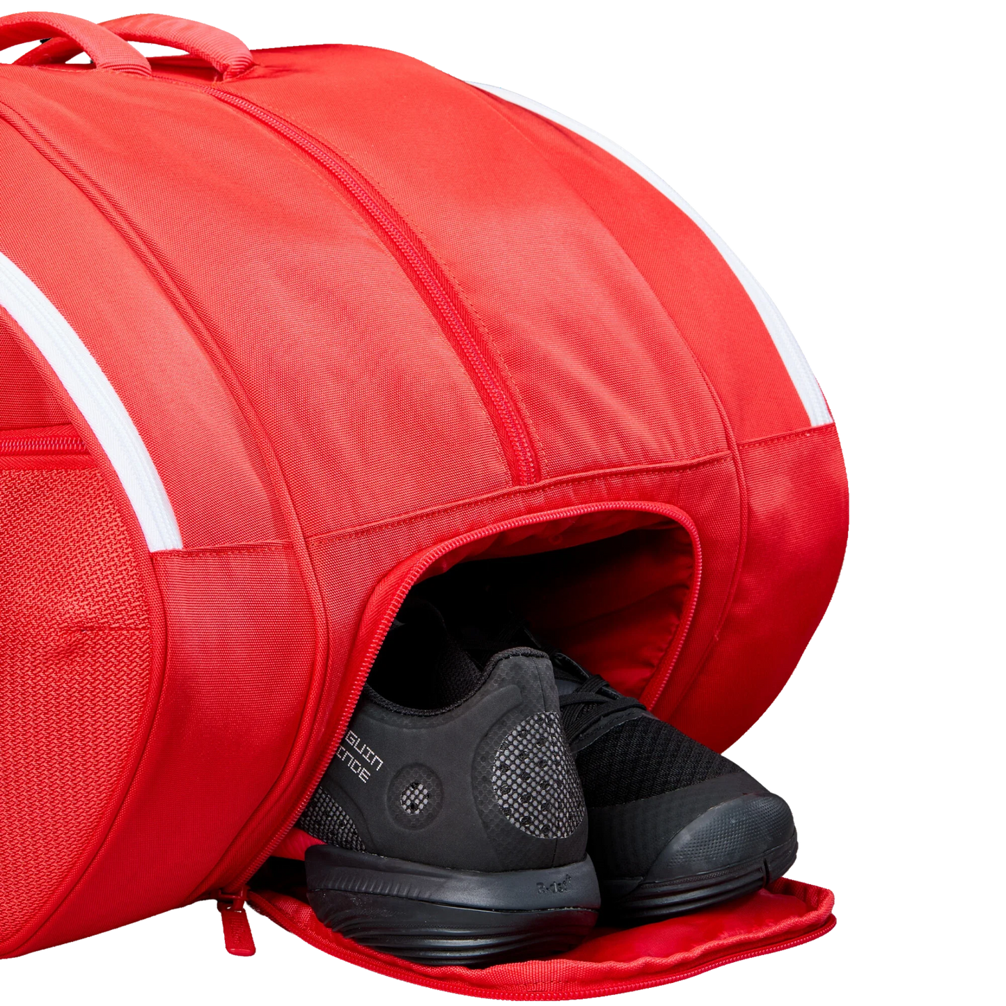 The Wilson Tour Red Padel Bag from Padel USA features Thermoguard technology, a zippered shoe compartment with black athletic shoes, white accents, textured fabric, and sturdy stitching for style and function.